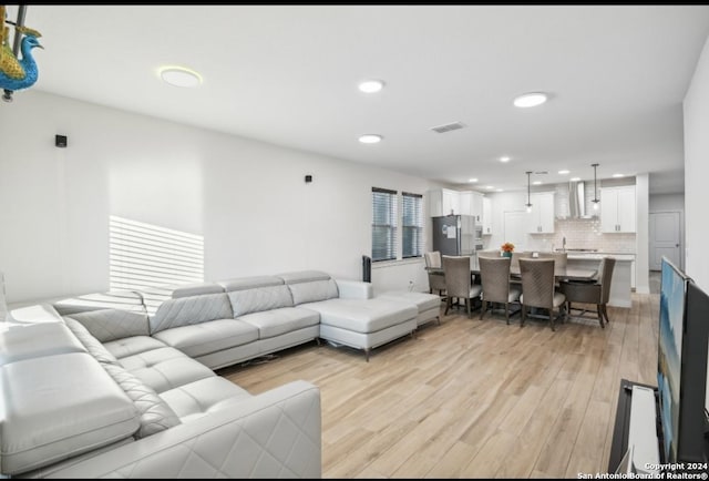 living room with sink and light wood-type flooring