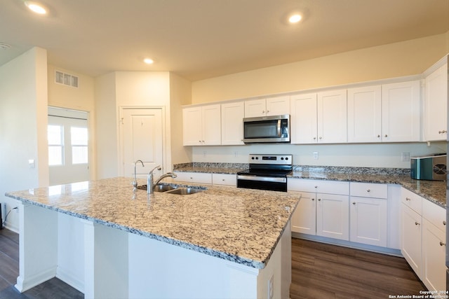 kitchen featuring dark wood-type flooring, a center island with sink, white cabinets, sink, and appliances with stainless steel finishes