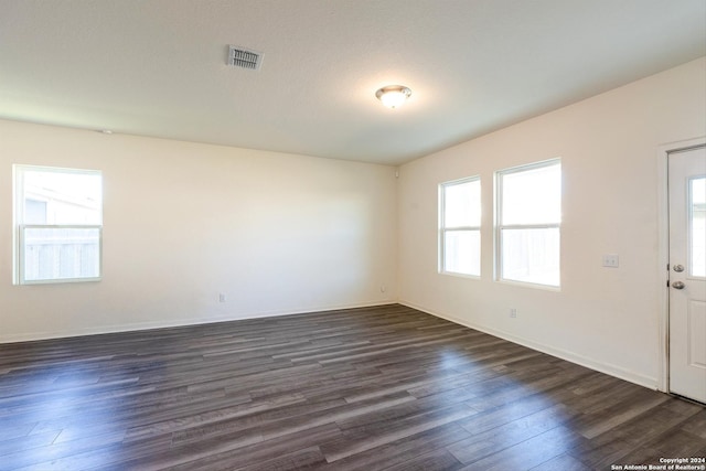 unfurnished room with dark hardwood / wood-style floors and a textured ceiling