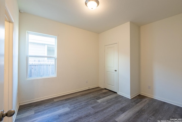 unfurnished room featuring dark wood-type flooring