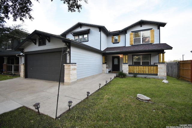 craftsman house featuring covered porch, a front yard, and a garage