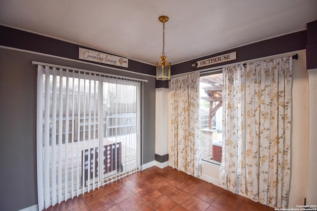 unfurnished room featuring dark tile patterned floors and plenty of natural light