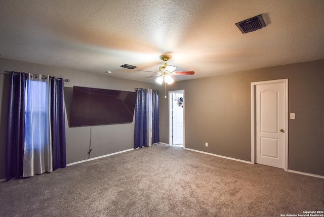 spare room featuring carpet flooring, a textured ceiling, and ceiling fan