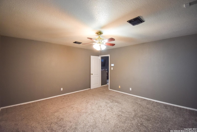 spare room featuring carpet, a textured ceiling, and ceiling fan