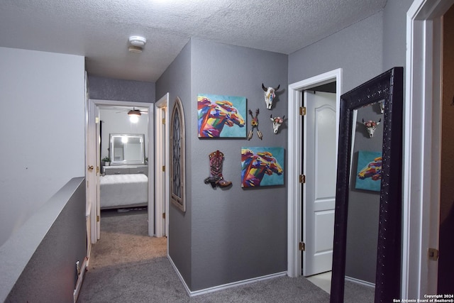 hall with carpet and a textured ceiling