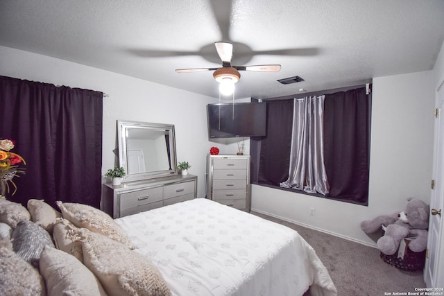 carpeted bedroom featuring a textured ceiling and ceiling fan