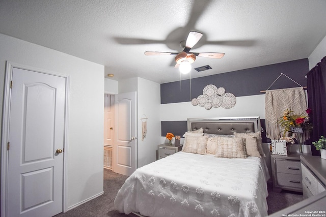 bedroom featuring a textured ceiling, dark carpet, and ceiling fan