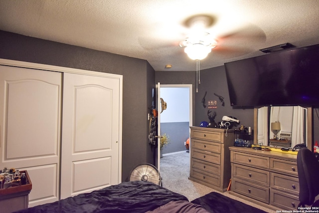 carpeted bedroom featuring ceiling fan, a textured ceiling, and a closet