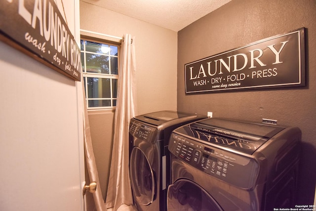 laundry room with a textured ceiling and washing machine and clothes dryer