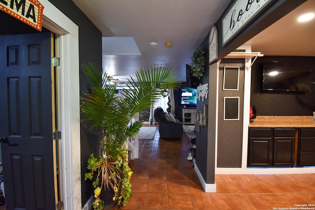 hallway featuring dark tile patterned floors