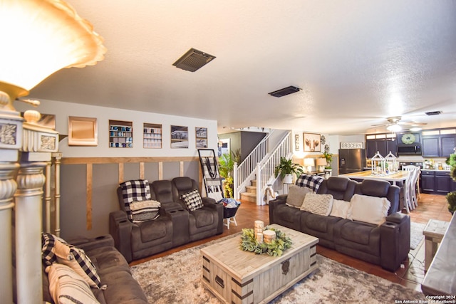 living room with ceiling fan and a textured ceiling