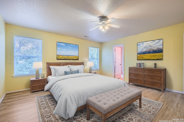 4735 Brook N, San Antonio, TX 78238 - bedroom with light wood finished floors, baseboards, a ceiling fan, and a textured ceiling