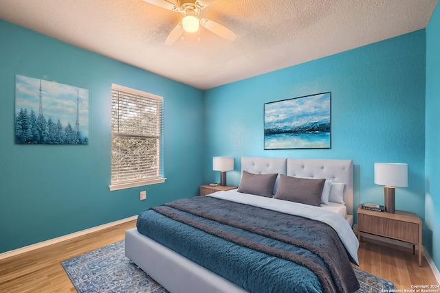 bedroom featuring wood-type flooring, a textured ceiling, and ceiling fan