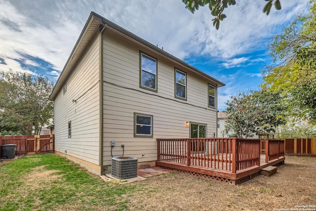 rear view of house featuring a lawn, a wooden deck, and cooling unit