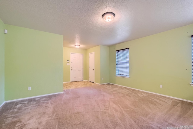 carpeted spare room with a textured ceiling