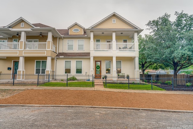 view of front of home with ceiling fan and a balcony