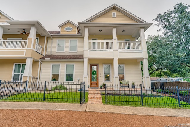 view of front of house with ceiling fan and a balcony