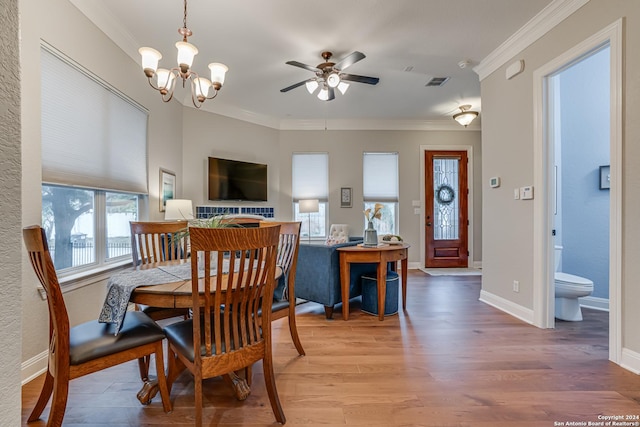 dining room with hardwood / wood-style flooring, ceiling fan with notable chandelier, and crown molding