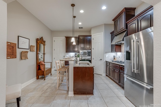 kitchen with pendant lighting, sink, decorative backsplash, an island with sink, and stainless steel appliances