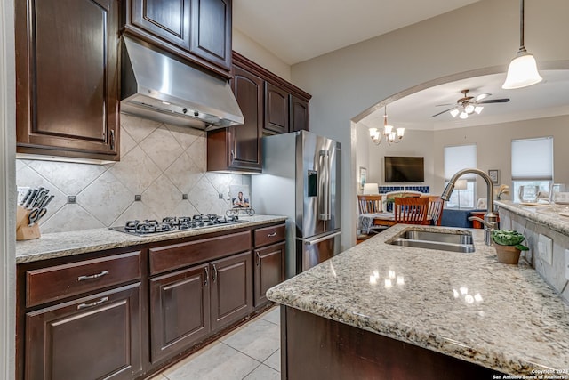 kitchen with ceiling fan with notable chandelier, sink, light tile patterned floors, decorative light fixtures, and dark brown cabinetry