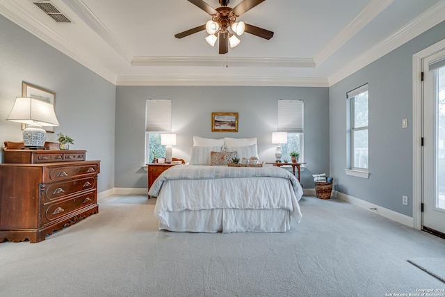 bedroom featuring light carpet, a tray ceiling, and ceiling fan