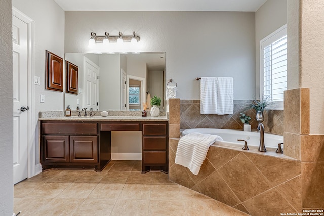 bathroom featuring tile patterned floors, tiled bath, and vanity