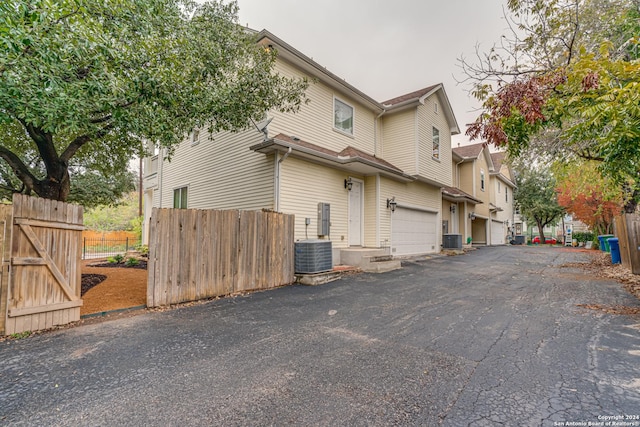 view of front of home featuring central AC and a garage