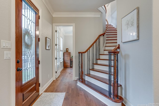 entryway with wood-type flooring and ornamental molding