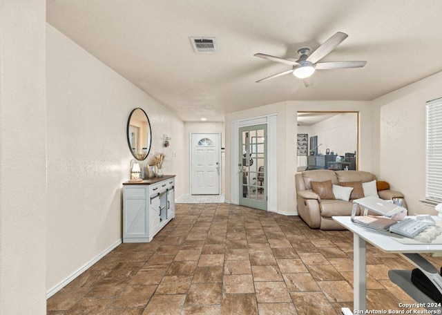 interior space with ceiling fan