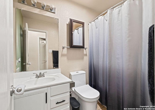 bathroom featuring tile patterned flooring, vanity, and toilet