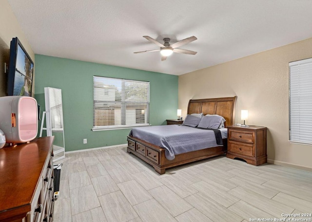 bedroom featuring a textured ceiling, light hardwood / wood-style flooring, and ceiling fan