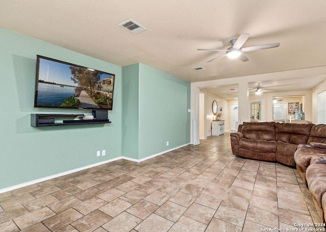 living room with ceiling fan and a textured ceiling