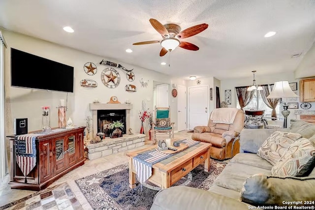 living room with ceiling fan and a stone fireplace