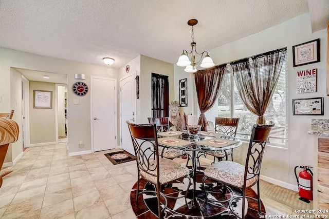 dining room featuring a chandelier, light tile patterned floors, and a textured ceiling