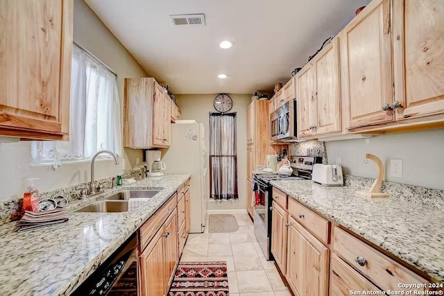 kitchen with sink, stainless steel appliances, and light brown cabinetry