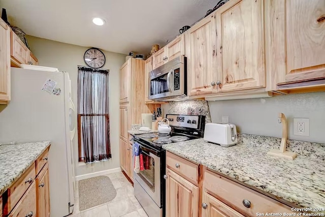 kitchen with appliances with stainless steel finishes, light brown cabinets, and light stone counters