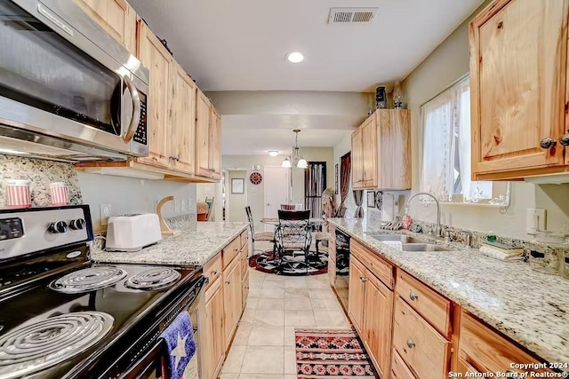 kitchen featuring black appliances, sink, hanging light fixtures, a notable chandelier, and light stone counters