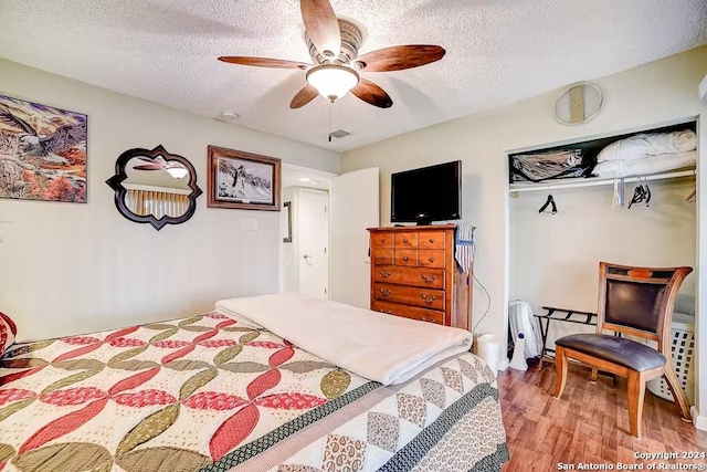 bedroom featuring hardwood / wood-style flooring, ceiling fan, a textured ceiling, and a closet