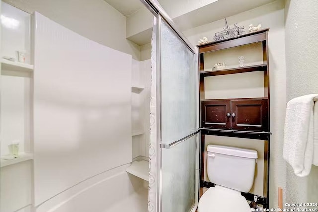 bathroom with a shower with shower door and toilet