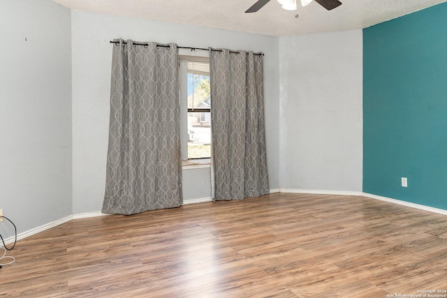 unfurnished room with ceiling fan, wood-type flooring, and a textured ceiling