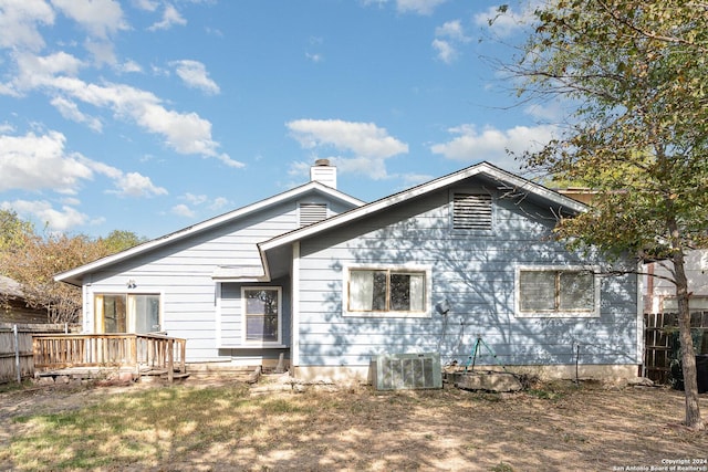 back of house featuring central air condition unit and a wooden deck