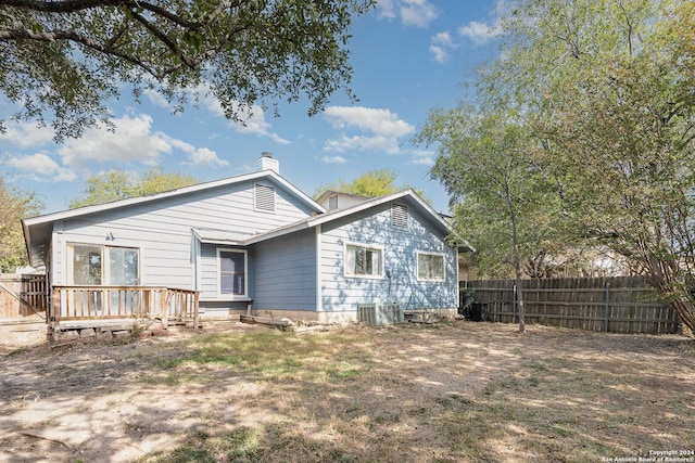 rear view of property featuring a wooden deck and cooling unit