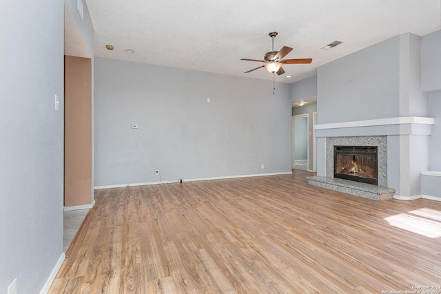 unfurnished living room featuring a textured ceiling, light hardwood / wood-style flooring, and ceiling fan