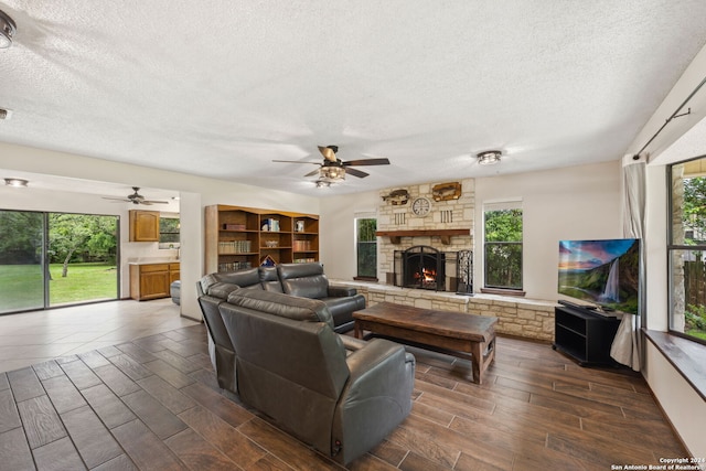 living room with a textured ceiling, dark hardwood / wood-style flooring, and a healthy amount of sunlight