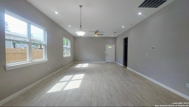 empty room with light hardwood / wood-style flooring and ceiling fan