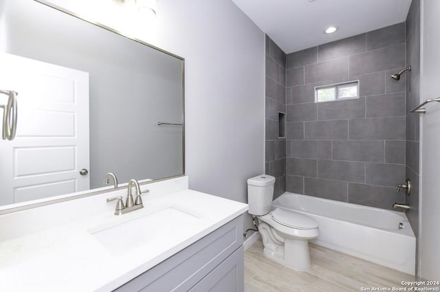 full bathroom with wood-type flooring, vanity, toilet, and tiled shower / bath