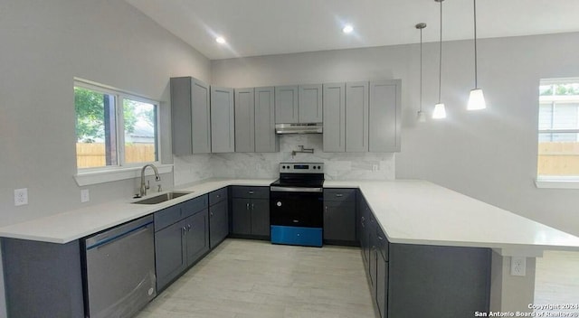 kitchen with kitchen peninsula, decorative light fixtures, stainless steel appliances, and a wealth of natural light