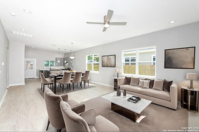 living room with ceiling fan and light wood-type flooring