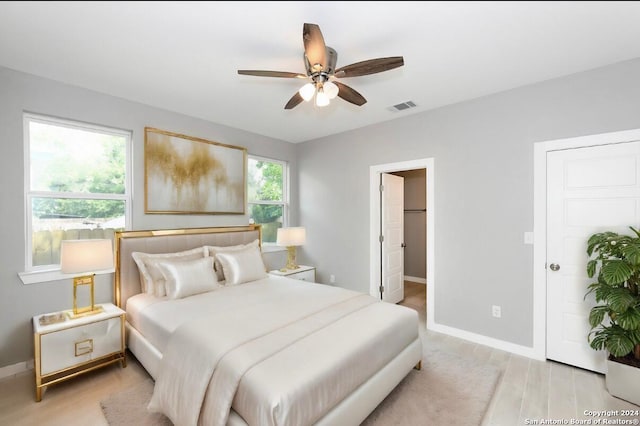 bedroom featuring ensuite bath, ceiling fan, and light hardwood / wood-style flooring