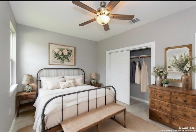 bedroom featuring ceiling fan, a closet, and light wood-type flooring